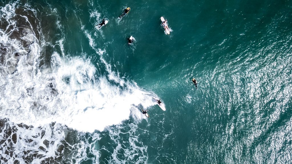 Bild von Surfer:innen auf einer Welle