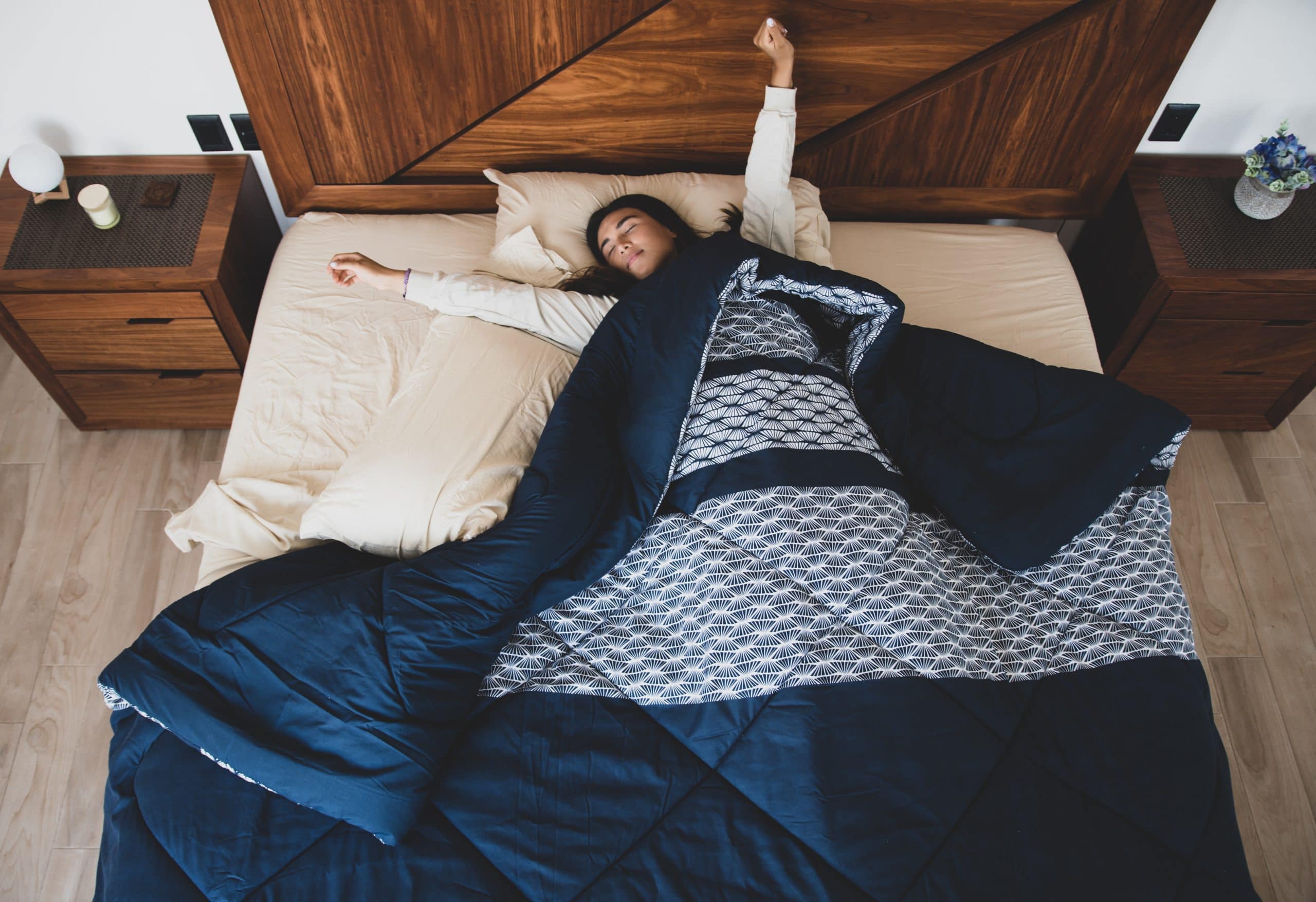 Frau streckt sich im Bett beim Aufwachen nach ihrem Biorhythmus