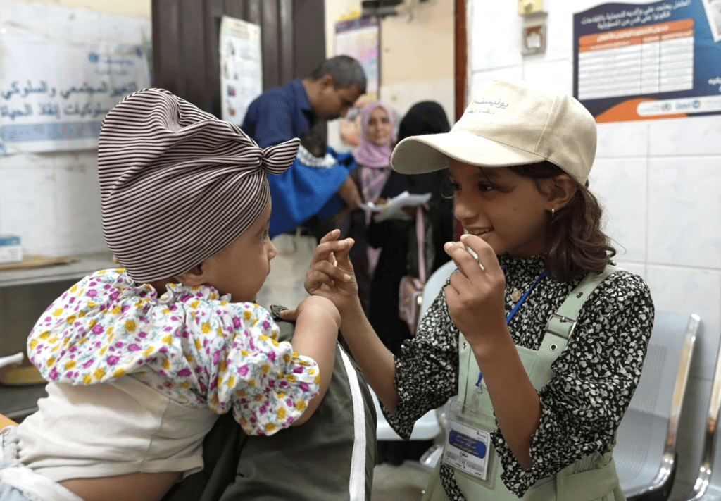 Leen Helmi ist mit ihren 10 Jahren wohl eine der jüngsten Impfhelferinnen im Jemen! Hier spielt sie mit einem Baby in einer Gesundheitseinrichtung, um es während der Impfung abzulenken. © UNICEF/UNI492623/Gabreez