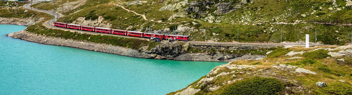 Zug in den Bergen und an einem See | Interrail durch Europa