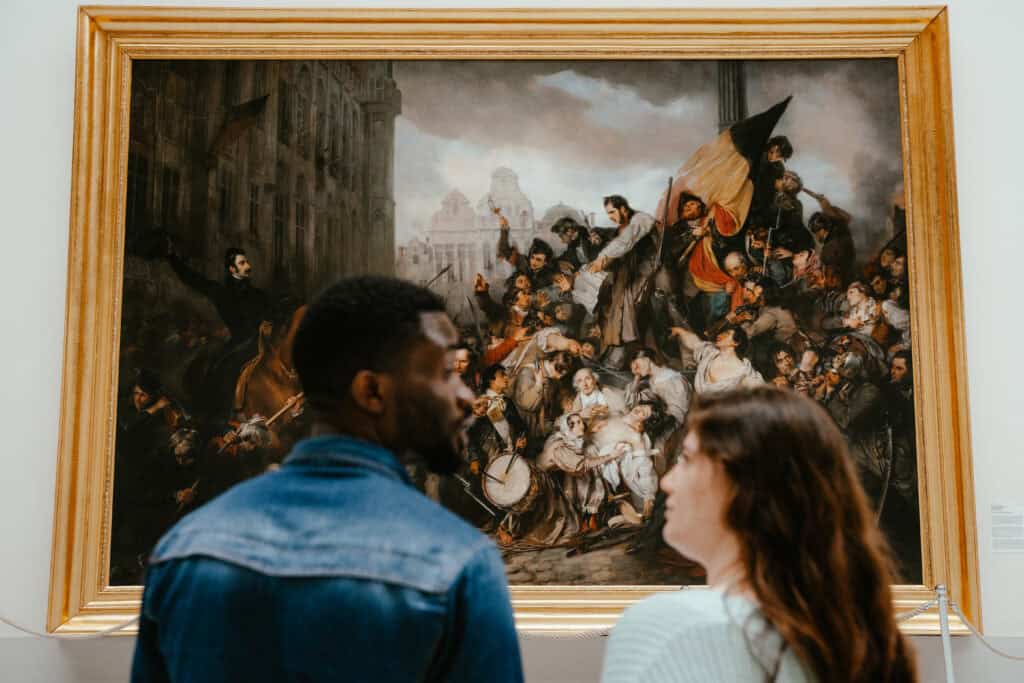 Zwei Personen vor einem Gemälde im Museum. 