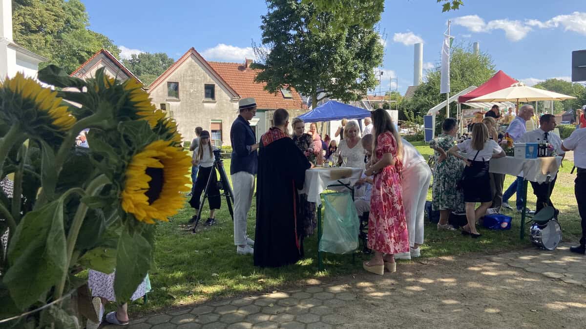 Hochzeitsgesellschaft draussen. Menschen an Stehtischen.