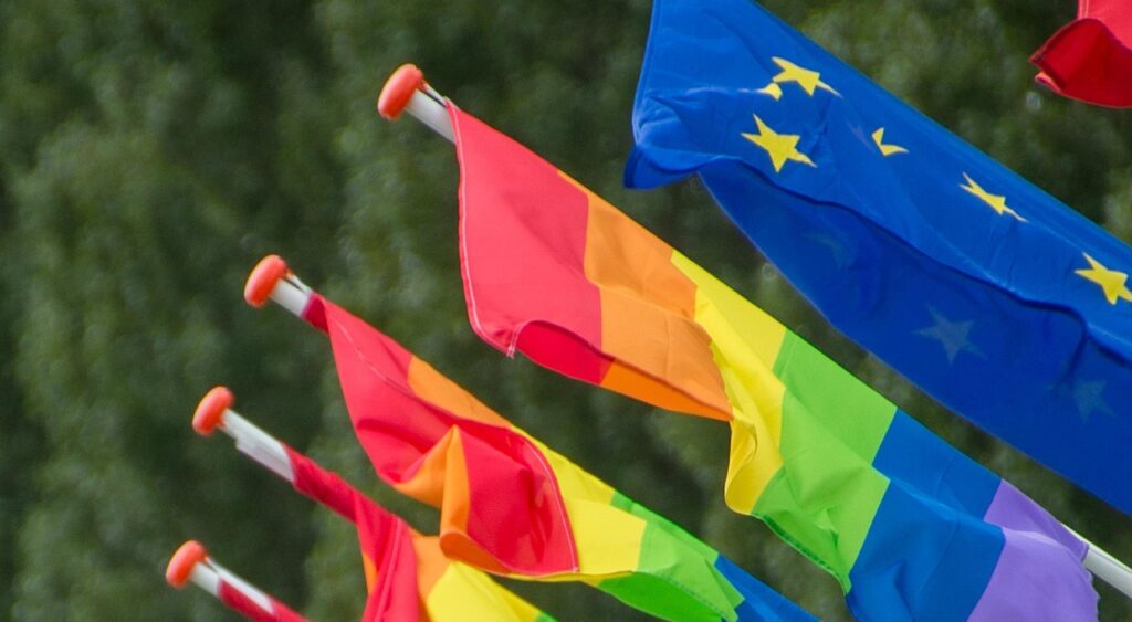 Regenbogenflagge und europäische Flagge.