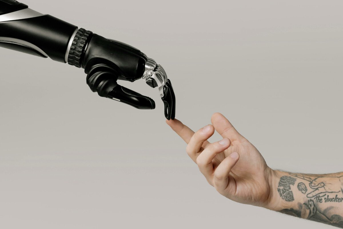 Meta KI - Symbolbild für künstliche Intelligenz - Eine Menschenhand berührt eine Roboterhand in Anlehnung an Michelangelos "Die Erschaffung Adams"