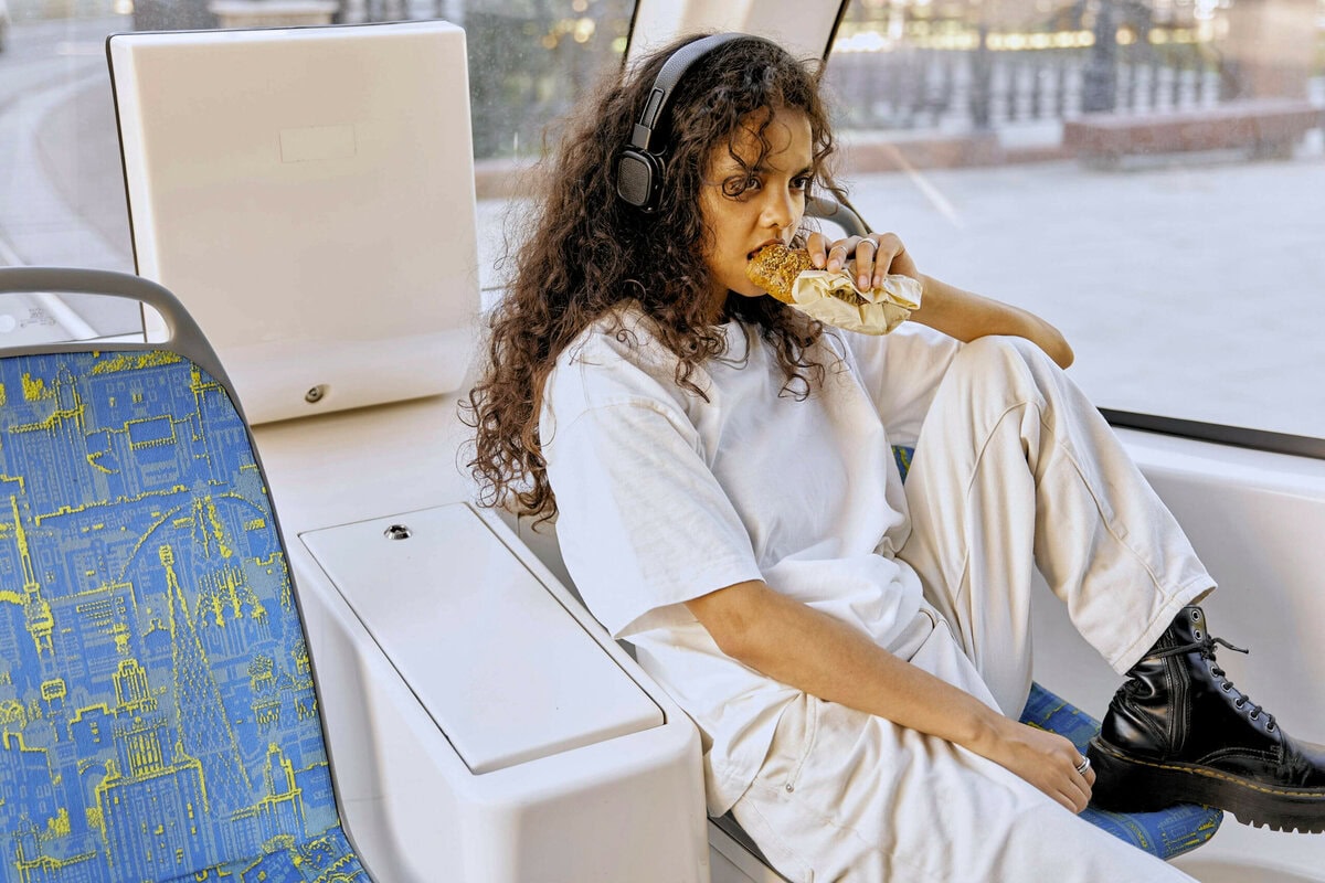 Mädchen mit Kopfhörern im Bus. Australiens Sensory Bus ist Rückzugsort für neurodivergente Menschen. Credits: https://www.pexels.com/de-de/foto/brot-essen-sitzung-sitzen-8722117