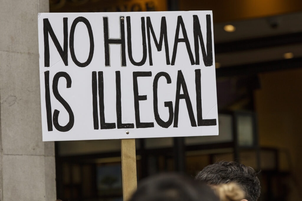 Kein Mensch ist illegal - No Human Is Illegal - Ninguna Persona Es Ilegal - Foto: https://depositphotos.com/de/editorial/no-human-is-illegal-protest-banner-at-a-political-march-311063370.html