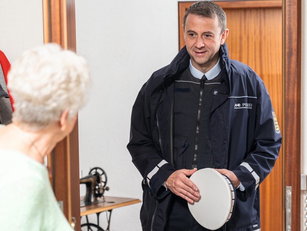Fürsorge statt bloßer Formalismus - ein Polizist an der Wohnungstür einer alten Frau - Bildrechte: www.polizei-beratung.de