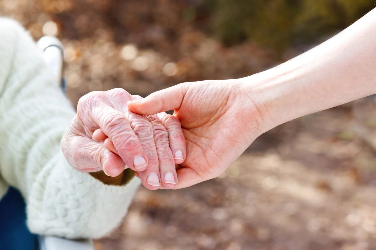 Jung Hand und alte Hand fassen ineinander