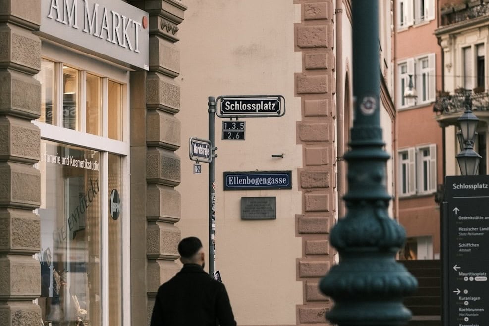 Mann bewegt sich vor Straßenschildern in Wiesbaden.